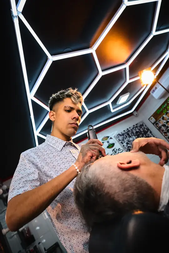 Barbero trabajando bajo las luces hexagonales
